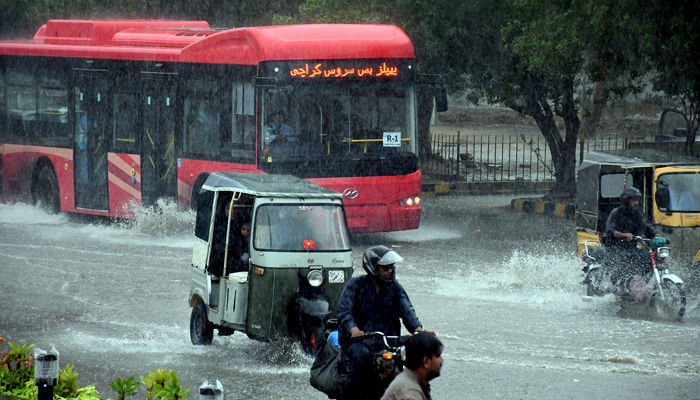 Commuters struggle to move forward in a flooded street after heavy monsoon rain in Karachi on July 05. -Online