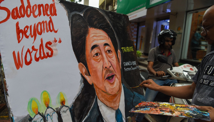 An artists gives final tocuhes to a painting of former Japanese prime minister Shinzo Abe, in Mumbai on July 8, 2022, to pay tribute following his death after he was shot at a campaign event in the Japanese city of Nara. -AFP