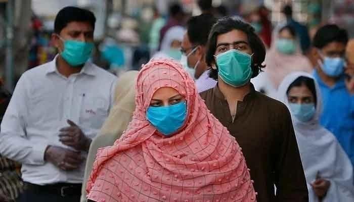 Pedestrians in a market wearing masks amid rising COVID-19 cases in Pakistan. Photo: AFP