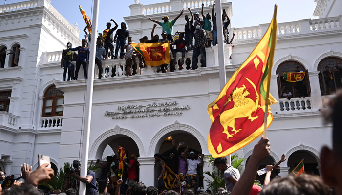Demonstrators shout slogans and wave Sri Lankan flags during an anti-government protest inside the office building of Sri Lanka´s prime minister in Colombo on July 13, 2022.-AFP