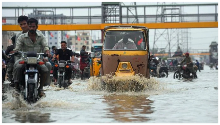 Image showing motorcycles and a rickshaw on a flooded road of Karachi. — AFP/ File