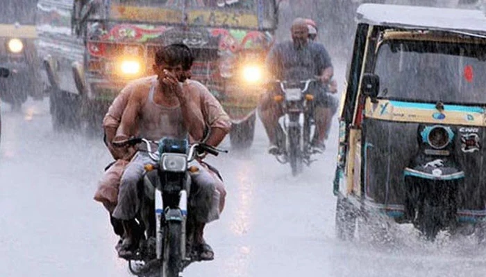 Motorists seen crossing a road filled with rainwater in Karachi. — Twitter/ File