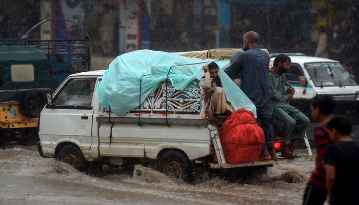 A pick-up vehicle drives through rainwater in Karachi. — AFP/File