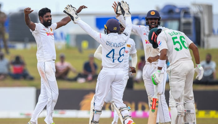 Sri Lanka´s Prabath Jayasuriya (L) celebrates with teammates after taking the wicket of Pakistans Babar Azam (R) during the final day of the second cricket Test match between Sri Lanka and Pakistan at the Galle International Cricket Stadium in Galle on July 28, 2022. -AFP