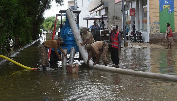 Troops use a water pump to remove water from a flooded residential area following heavy monsoon rains in Karachi on July 26, 2022. — AFP