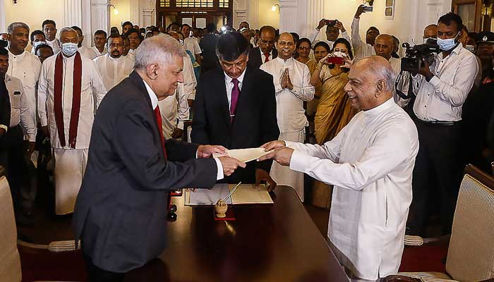 Sri Lankan President Ranil Wickremesinghe (L) swears in Dinesh Gunawardena (R) as the new premier of the country, at the Prime Minister’s office in Colombo on July 22, 2022. Photo: AFP/file