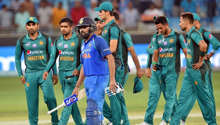 Indian cricketer, Rohit Sharma (C) and Pakistan team leave the field after India won by 9 wickets during the one day international match between Pakistan and India at the Dubai International Cricket Stadium in Dubai. — AFP/File