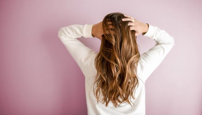 Woman holds her hair. —Unsplash