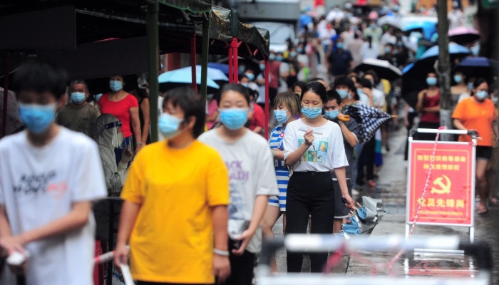 Lunedì, residenti e turisti nella provincia cinese meridionale di Hainan si mettono in fila per sottoporsi al test per il coronavirus.  — AFP