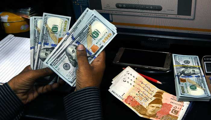 A Pakistani dealer counts US dollars at a currency exchange shop in Karachi. Photo: AFP/File