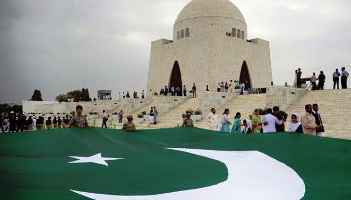 A big flag of Pakistan is seen with the tomb of Quaid-e-Azam in the background amid Independence Day celebration in Karachi. — AFP/File
