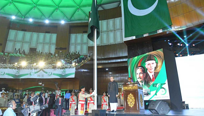 Prime Minister Shehbaz Sharif stands as a cadet pulls the rope to hoist the national flag during Independence Day celebration at Jinnah Convention center in Islamabad. — PM Office