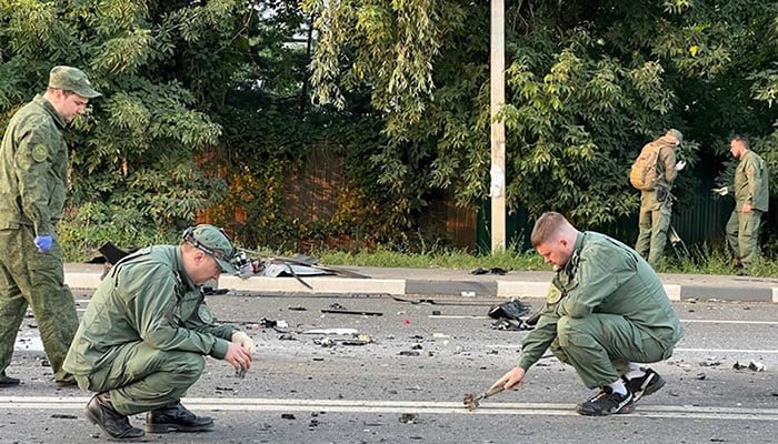 This handout picture released by the Russian Investigative Committee on August 21, 2022 shows investigators work on the place of explosion of a car driven by Daria Dugina, daughter of Alexader Dugin, a hardline Russian ideologue close to President Vladimir Putin, outside Moscow. — AFP