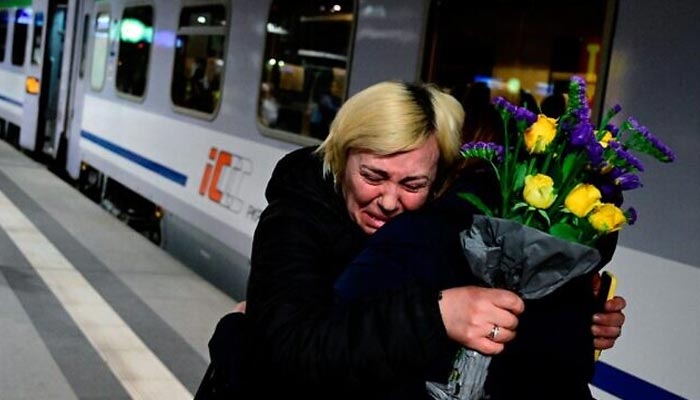 A refugee woman cries while hugging a friend on arrival to Berlins main train station after journeying from Ukraines border in March — AFP/File