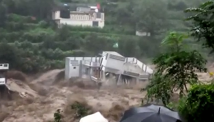 This screengrab shows a house being washed away in a flood.