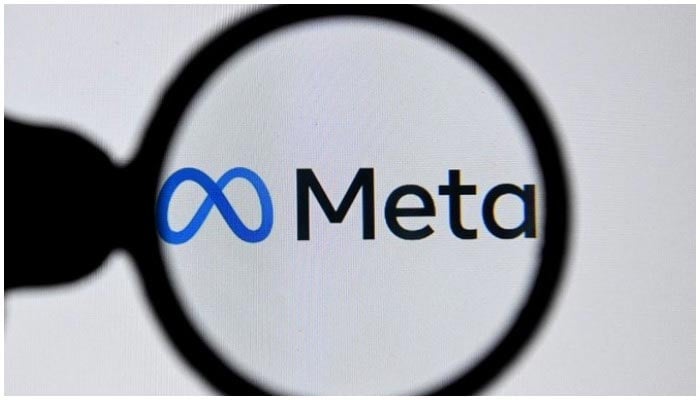 Image showing the logo of Meta as seen through a magnifying glass. — AFP/File