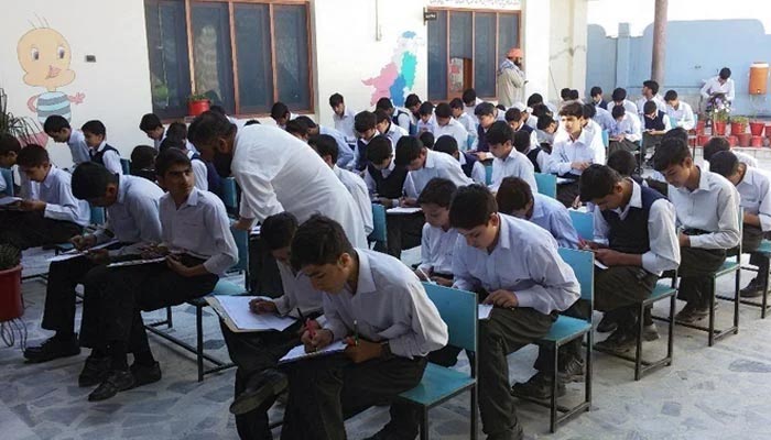 Male students give their exams at a designated examination centre. — AFP/File