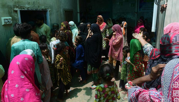 A representational image of flood-affected women standing in a queue looking for aid. — AFP/File