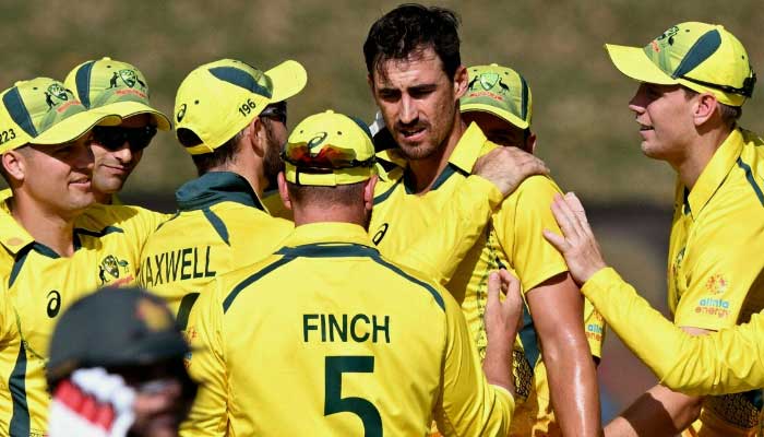 Australia’s bowler Mitchell Starc (C) is congratulated by teammates after being the fastest player to take 200 T20 wickets, during the third one-day international (ODI) cricket match between Australia and Zimbabwe at the Riverway Stadium in Townsville on September 3, 2022. — AFP