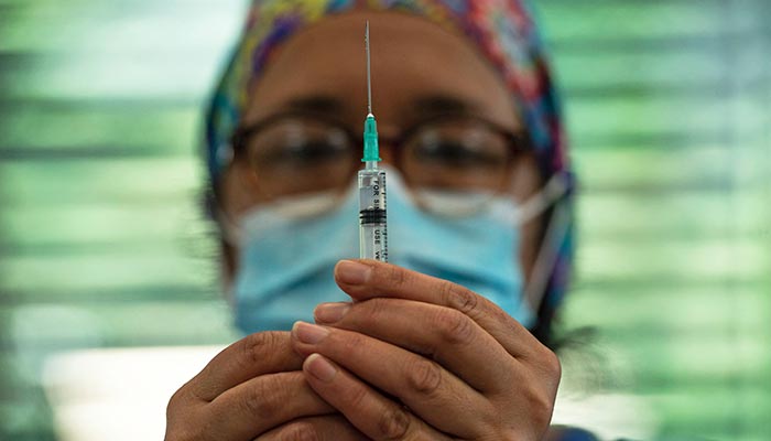 In this file photo taken on February 10, 2021, a healthcare worker holds a syringe with the Coronavac vaccine at a vaccination center in the Bicentenario Park, in Santiago. — AFP/File