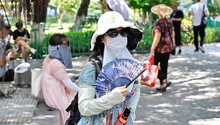 A Chinese woman fans herself amidst hot weather in the country. — AFP/File