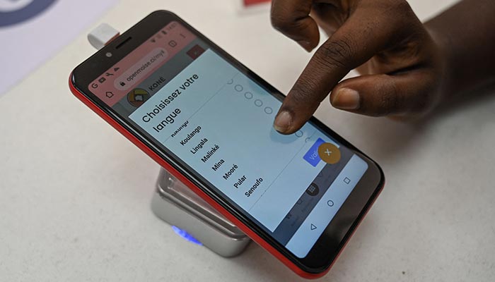 A woman chooses an African language on the Superphone made by Cerco at their showroom in Abidjan. — AFP/File