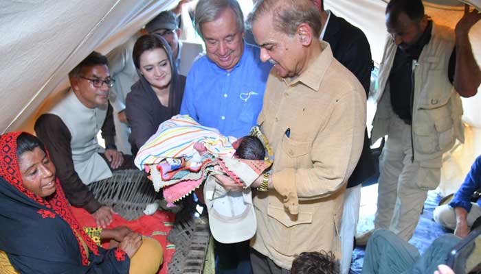 Prime Minister Shahbaz Sharif holds a new-born baby in a relief camp.