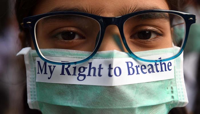 A young girl wears a mask with My Right to Breathe written over it. — AFP/File