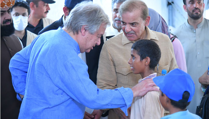 United Nations Secretary-General Antonio Guterres inquires after a child on his visit to flood affected areas in Pakistan, alongside PM Shehbaz Sharif. — Twitter/@CMShehbaz