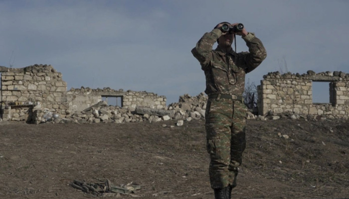 An ethnic Armenian soldier looks through binoculars near the village of Taghavard in the region of Nagorno-Karabakh, on January 11, 2021. File