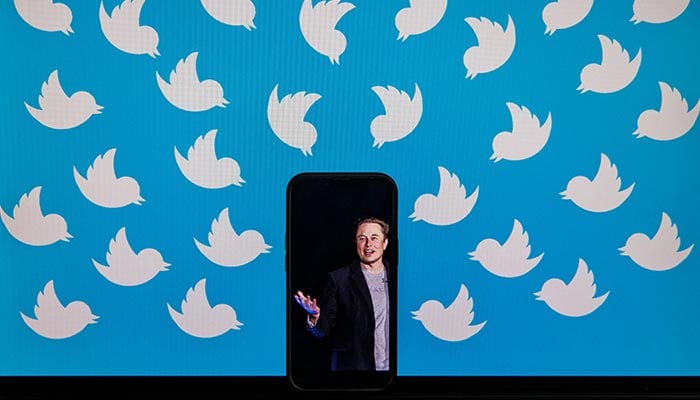 This file illustration photo taken on August 5, 2022 shows a cellphone displaying a photo of Elon Musk placed on a computer monitor filled with Twitter logos in Washington, DC. — AFP