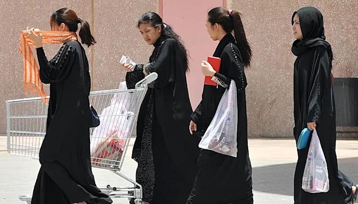 Filipino domestics workers wearing abayas walk on a street in Saudi Arabia. — AFP/File