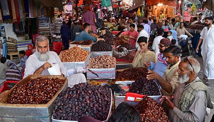 Customers buy dry fruits from a kiosk in a market. — AFP/File