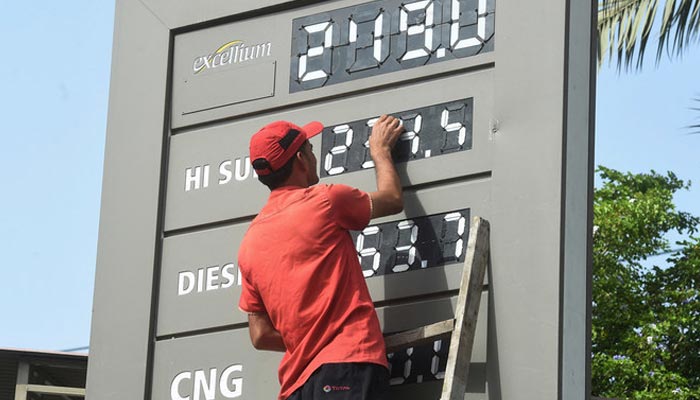 A petrol station staffer updates the latest fuel prices in Karachi. — AFP/ File