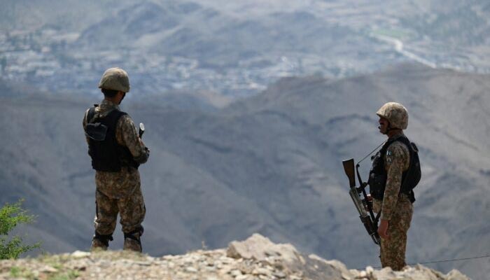 In this file photo, two Pakistan Army soldiers stand guard at a checkpost on a mountainous area. — AFP