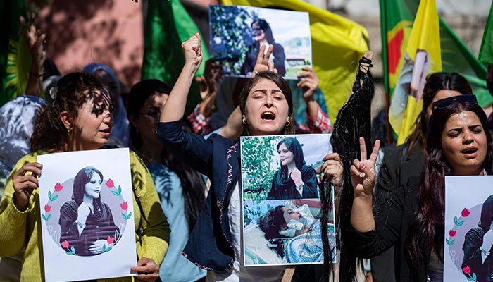 Syrian Kurdish women take part in a demonstration in Syria´s northeastern city of Hasakeh on September 25, 2022, to express their support for 22-year-old Mahsa Amini (portrait), who died while in the custody of Iranian authorities. — AFP