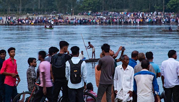 In this picture taken on September 25, 2022, people gather along the banks of the Karatoya river after a boat capsized near the town of Boda.— AFP/File