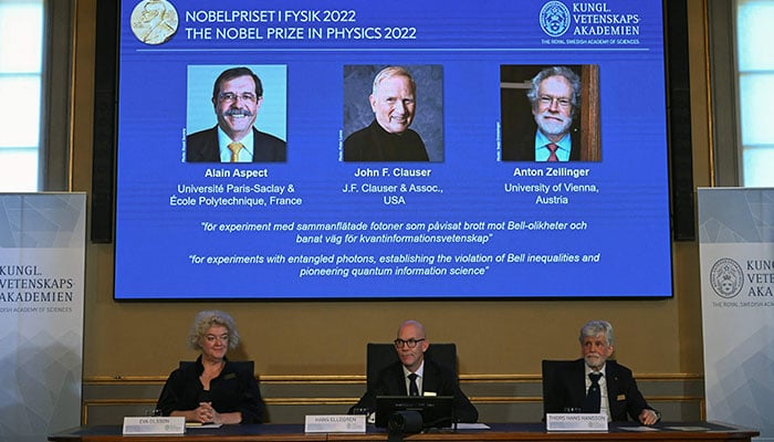 Members of the Nobel Committee for Physics (Bottom L-R) Eva Olsson, Secretary General of the Royal Swedish Academy of Sciences Hans Ellegren and Thors Hans Hansson announce the 2022 Nobel Prize in Physics winners (On display L-R) French experimental physicist Alain Aspect, US theoretical and experimental physicist John Francis Clauser and Austrian quantum physicist Anton Zeilinger, at the Royal Swedish Academy of Sciences in Stockholm, Sweden, on October 4, 2022. — AFP
