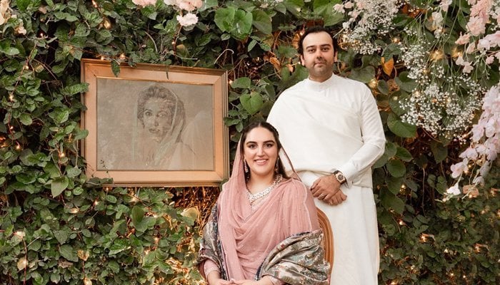 Bakhtawar Bhutto-Zardari and her husband, Mahmood Choudhary, pose for a photo against a backdrop of greenery and a picture of her late mother and former Pakistani prime minister, Benazir Bhutto, in Karachi, Pakistan, November 27, 2020. Twitter/Bakhtawar B-Zardari