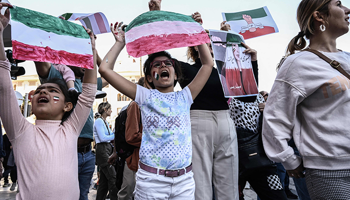 Iranians living in Greece chant slogans and hold placards in the colours of the Iranian flag during a demonstration, following the death in Tehran of an Iranian woman after her arrest by the countrys morality police, in Thessaloniki on October 8, 2022. — AFP