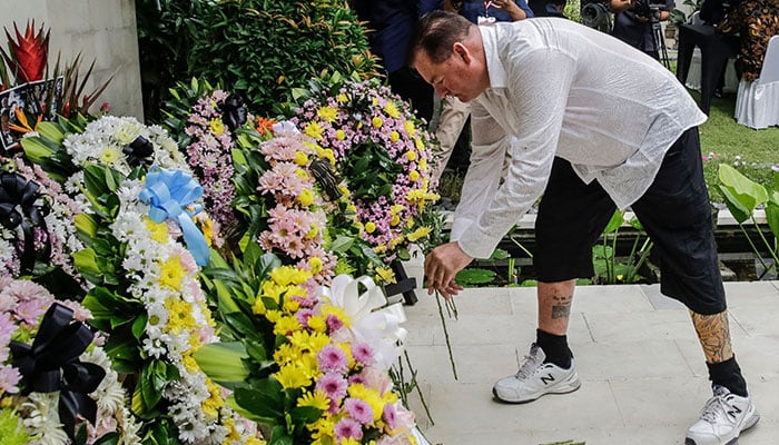Australian Bali bombing survivor Andrew Csabi lays flowers during a commemoration ceremony to mark the 20th anniversary of the Bali bombings that killed more than 200 people, at the Australian consulate in Denpasar on the Indonesian resort island of Bali on October 12, 2022. — AFP