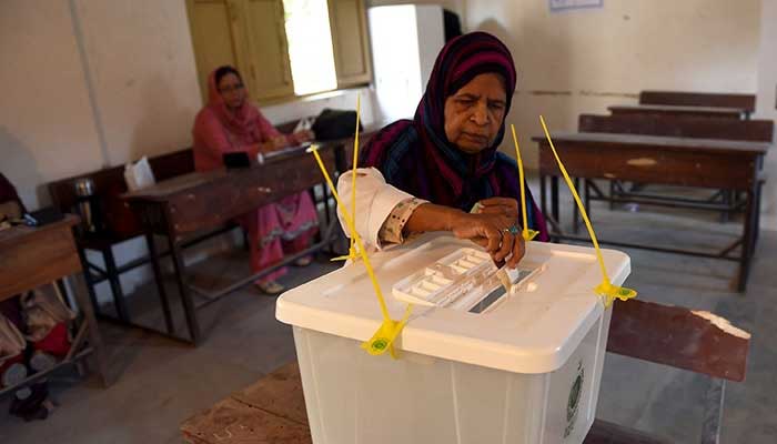 A woman casts her vote at a polling station in Karachi. —AFP