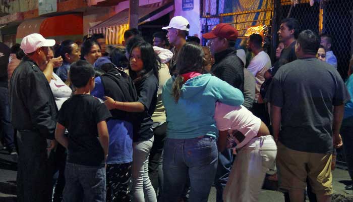 Relatives and friends react outside the bar where 12 people were killed by an armed group which opened fire on customers and staff, in Irapuato, state of Guanajuato, Mexico, on October 15, 2022. — AFP