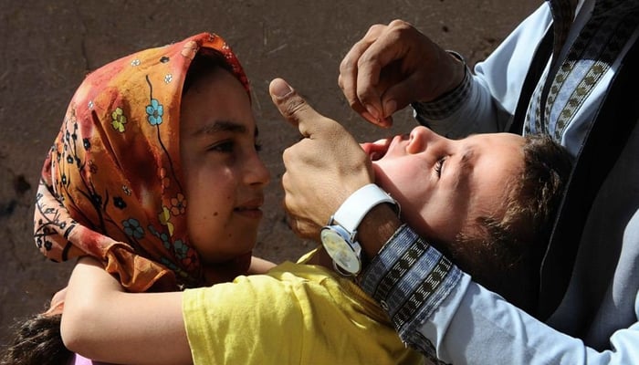 A child receiving polio drops by a health worker.  - AFP/File