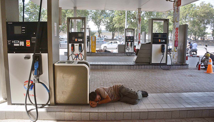 A gas station worker takes a nap after a major power breakdown took place on October 13, 2022, in Karachi. — APP