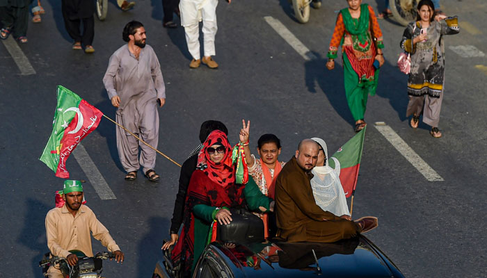 Activists of PTI party protest on a street against the disqualified decision of former prime minister Imran Khan in Karachi on October 21, 2022. — AFP