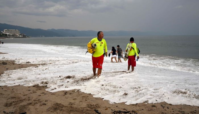 Two members of Civil Protection check the beach ahead of the arrival of Hurricane Roslyn, in the tourist area of Puerto Vallarta, Jalisco State, Mexico, on October 22, 2022.— AFP