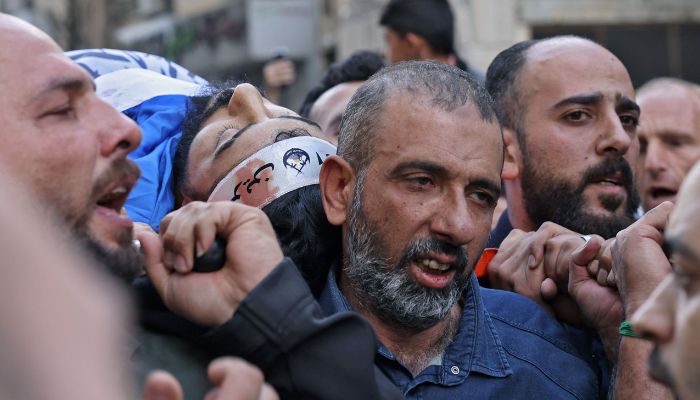 Mourners carry the body of a Palestinian who was among those killed in an overnight Israeli raid, during his funeral in the occupied West Bank city of Nablus on October 25, 2022.— AFP