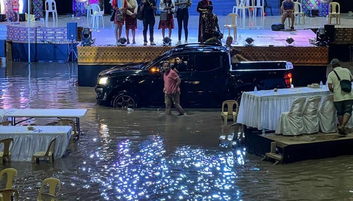 Residents trapped inside a gym in the town of Upi in Maguindanao province, southern Philippines, which was flooded after heavy rains brought about by tropical storm Nalgae. — AFP
