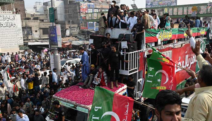PTI Chairman Imran Khan (C top) gestures to his supporters during an anti-government march towards Islamabad city, demanding early elections, in Muridke district on October 30, 2022. — AFP